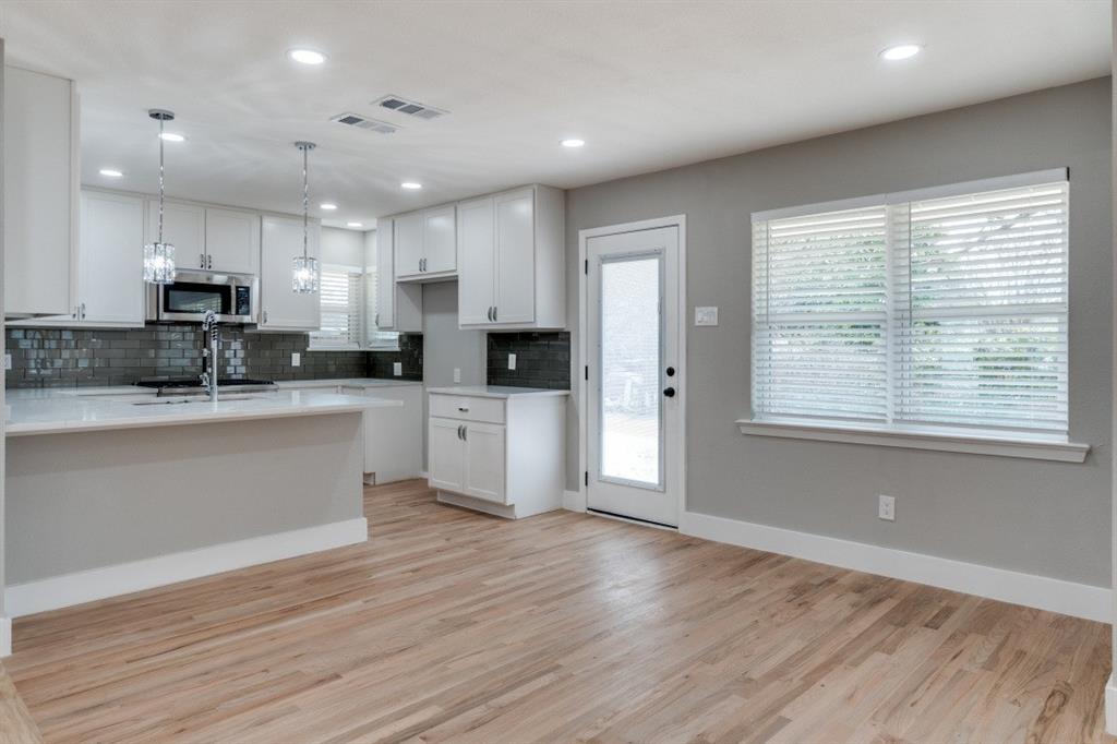2542 Delmac Drive Dallas, TX 75233 - Photo 8 of 20 a kitchen with stainless steel appliances kitchen island wooden cabinets and a wooden floor