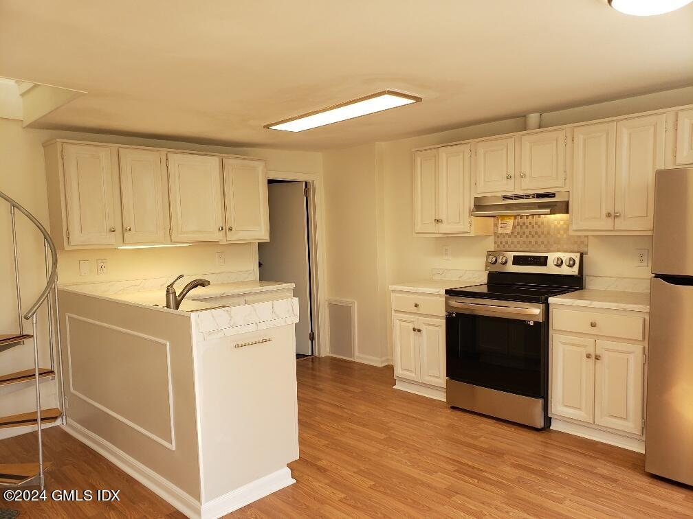 a kitchen with a refrigerator stove and white cabinets