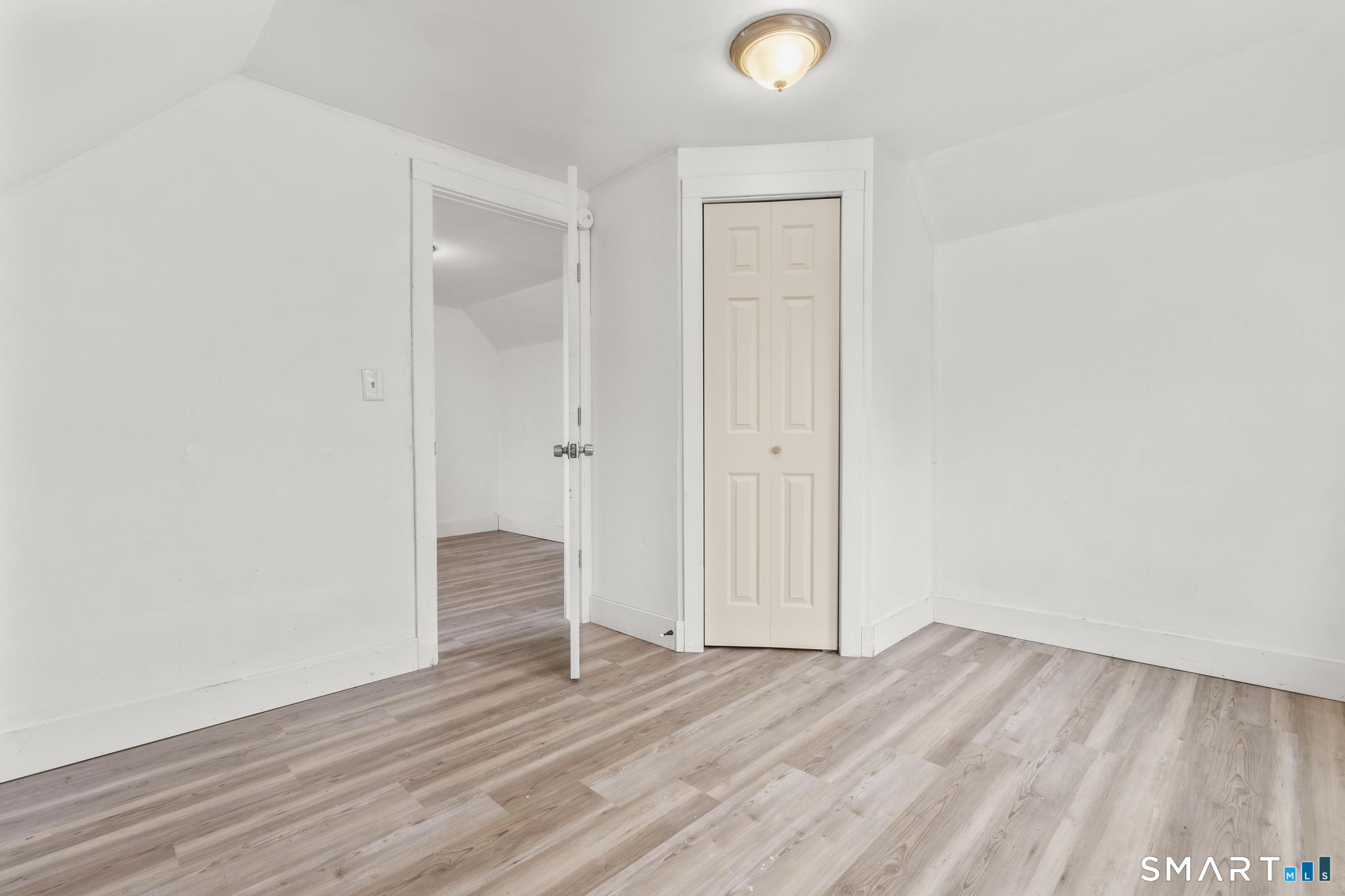 103 Walnut Street Waterbury, CT 06704 - Photo 13 of 38 a view of wooden floor and windows in a room