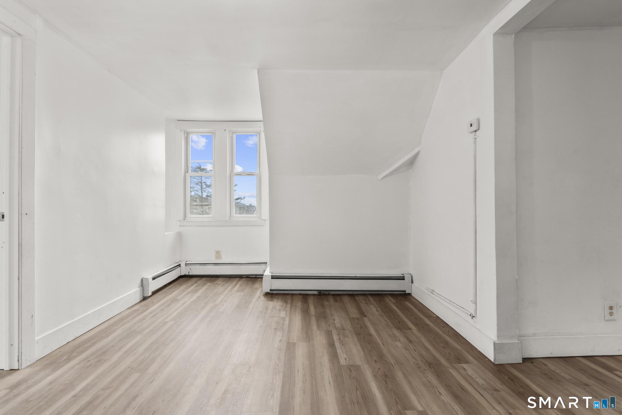 103 Walnut Street Waterbury, CT 06704 - Photo 16 of 38 an empty room with wooden floor and windows