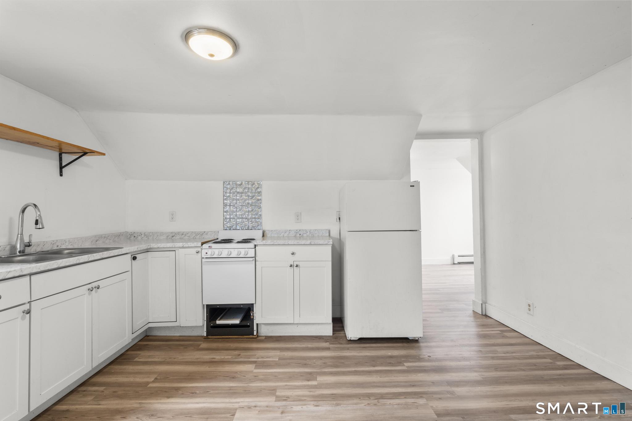 103 Walnut Street Waterbury, CT 06704 - Photo 21 of 38 a view of a kitchen with a sink wooden cabinets and entryway