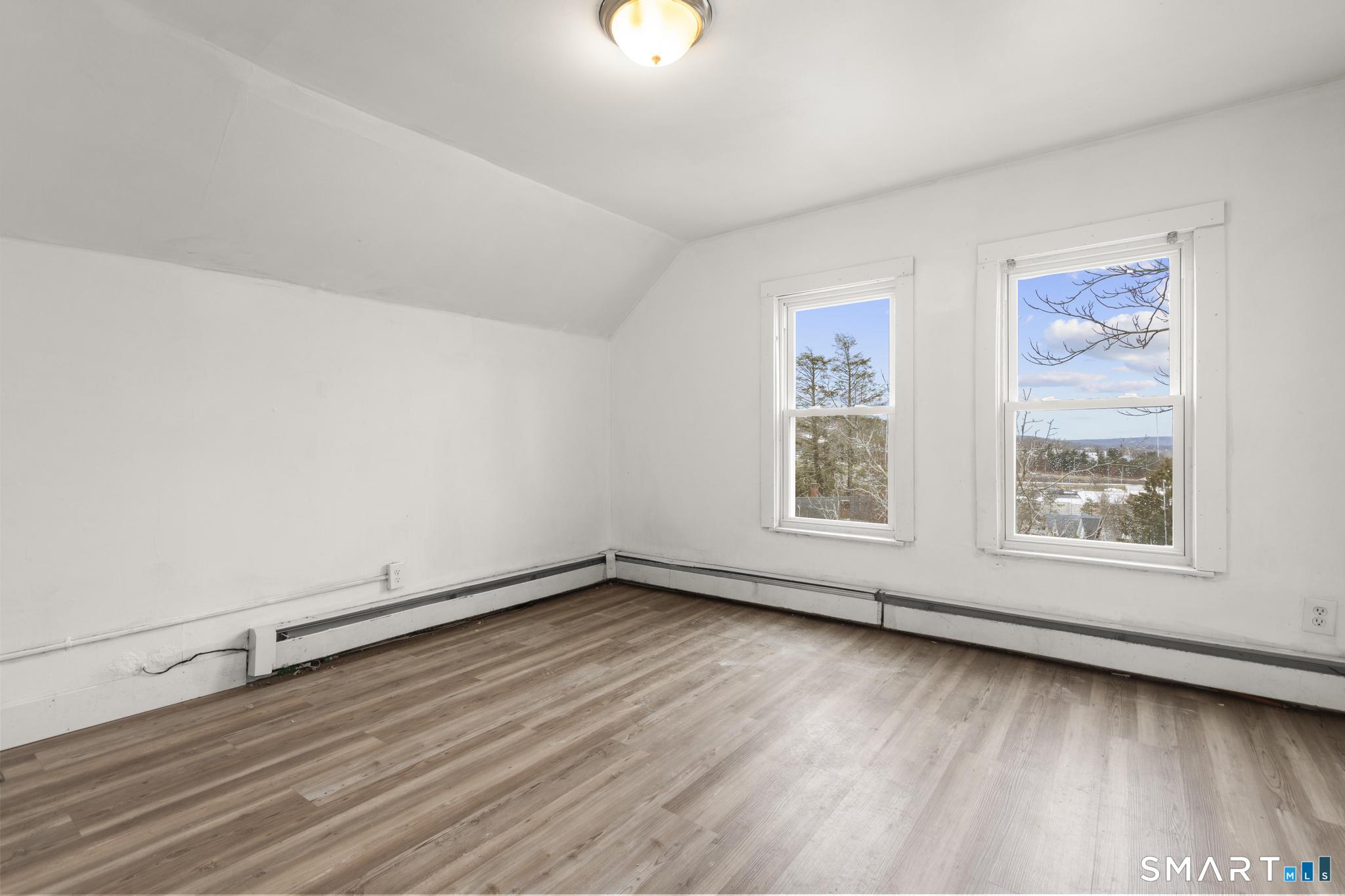 103 Walnut Street Waterbury, CT 06704 - Photo 27 of 38 an empty room with wooden floor and windows
