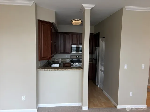 a kitchen with a refrigerator and a stove top oven