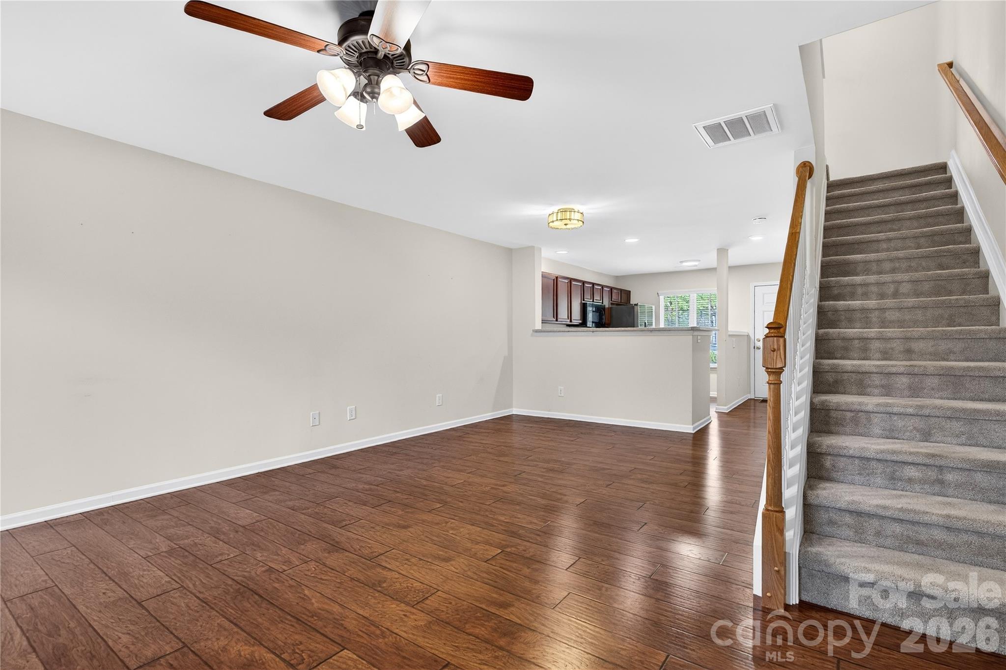 149 Marakery Road, Unit C Mooresville, NC 28115 - Photo 19 of 45 a view of an empty room with wooden floor and a ceiling fan