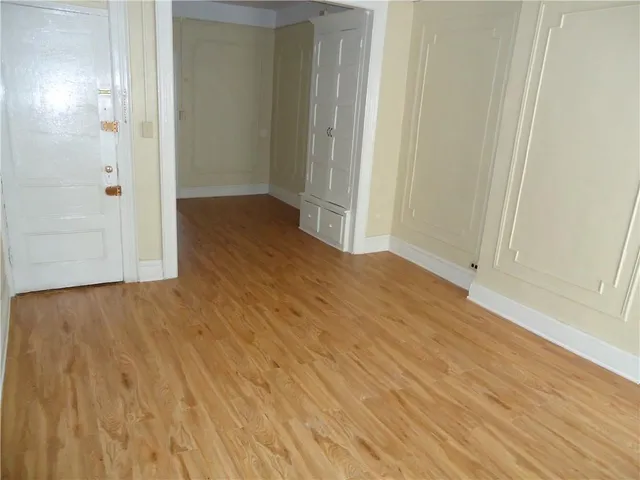 an empty room with wooden floor and sliding door