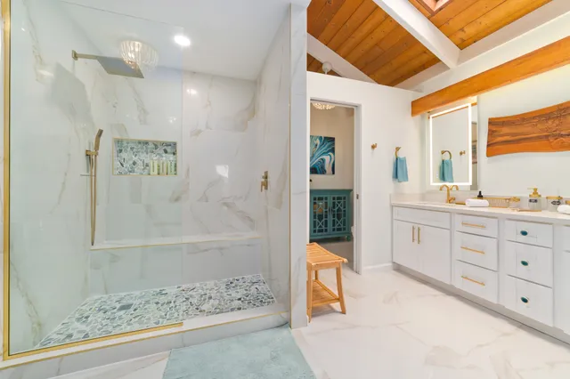 a spacious bathroom with a double vanity sink a large mirror and shower