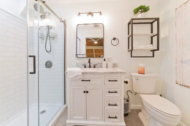 a bathroom with a granite countertop toilet sink and mirror