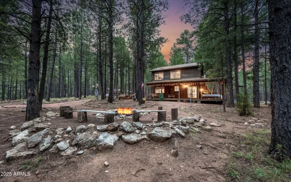 a backyard of a house with fire pit and outdoor seating
