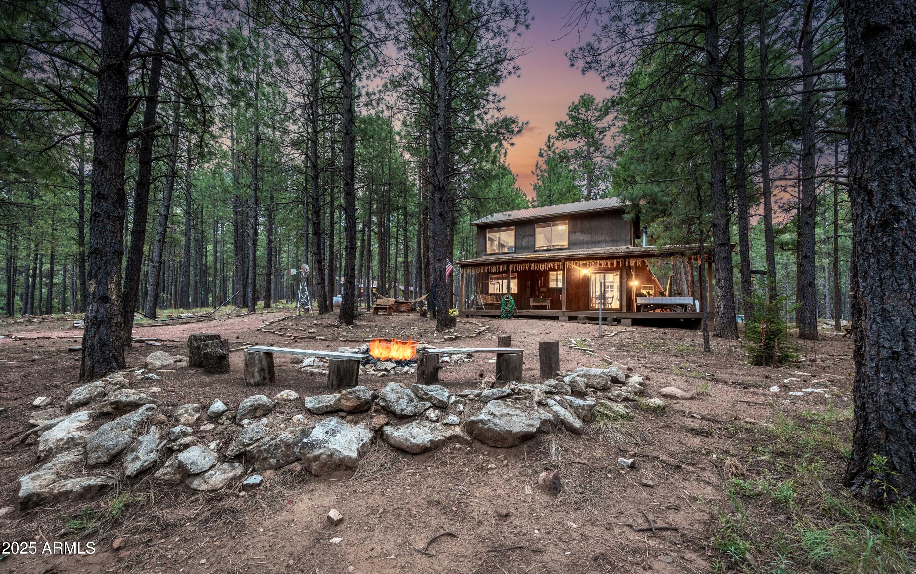 a backyard of a house with fire pit and outdoor seating