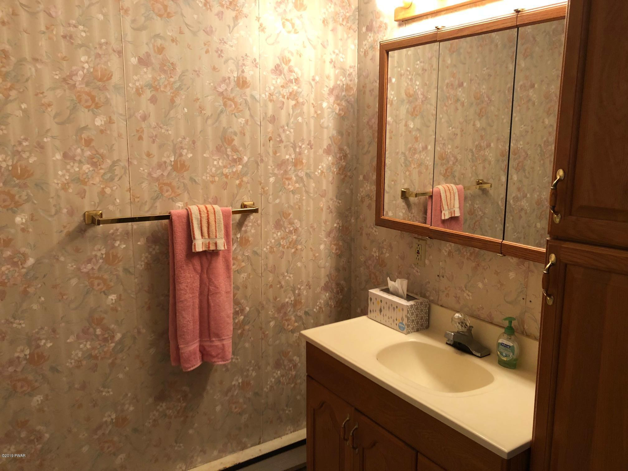 176 Heather Hill Road Dingmans Ferry, PA 18328 - Photo 23 of 32 a bathroom with a sink and mirror