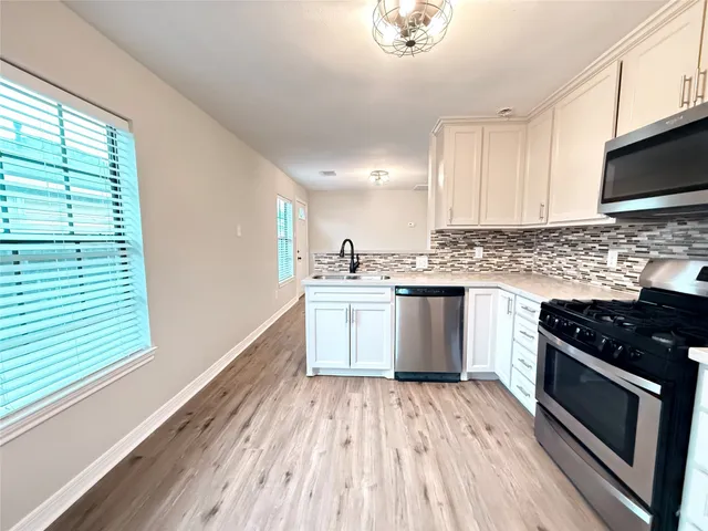 a kitchen with a sink stove and cabinets
