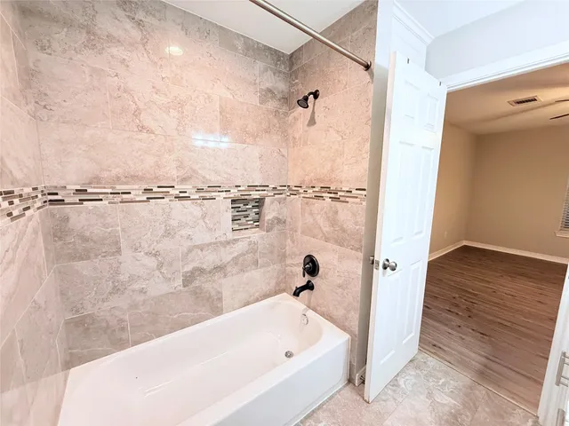 a bathroom with a bathtub and shower
