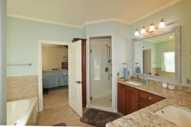 a en suite bathroom with a sink a large mirror and a shower