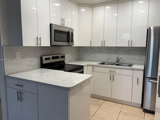 a kitchen with granite countertop white cabinets and stainless steel appliances