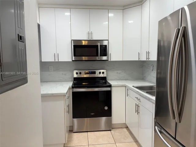 a kitchen with stainless steel appliances granite countertop a refrigerator stove and microwave