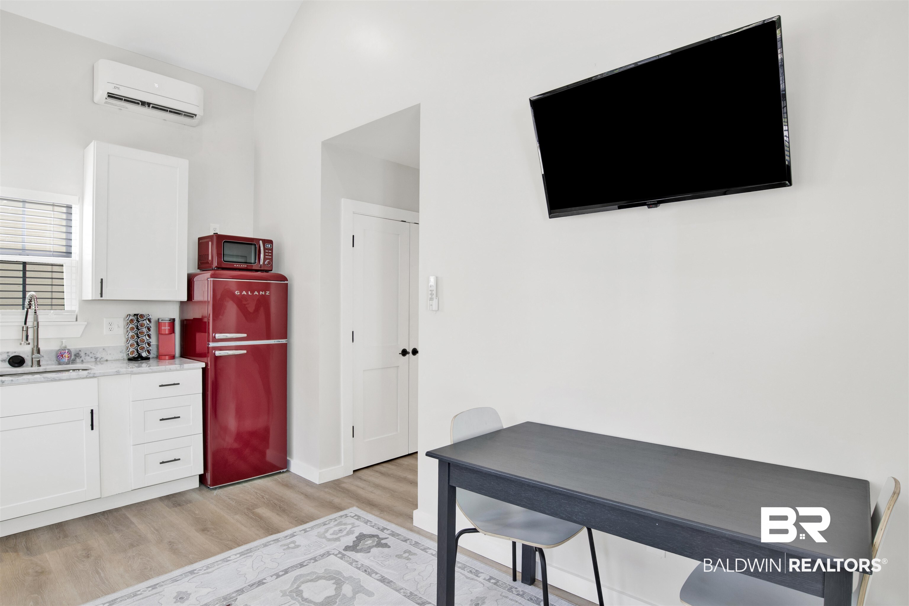 551 Congress Street Mobile, AL 36603 - Photo 9 of 19 Kitchen with white cabinetry, freestanding refrigerator, light wood finished floors, and light stone counters