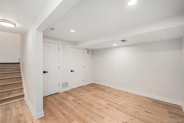 a view of a room with wooden floor and white doors