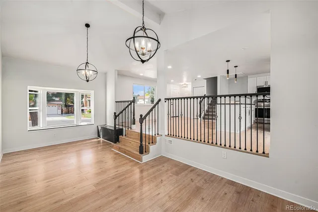 a view of a room with wooden floor fan and windows