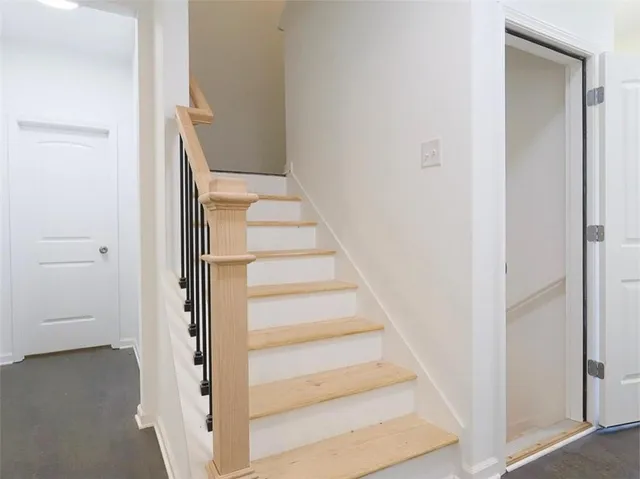 a view of staircase with white walls and white door