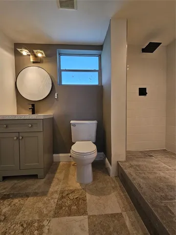 a bathroom with a toilet a sink and mirror
