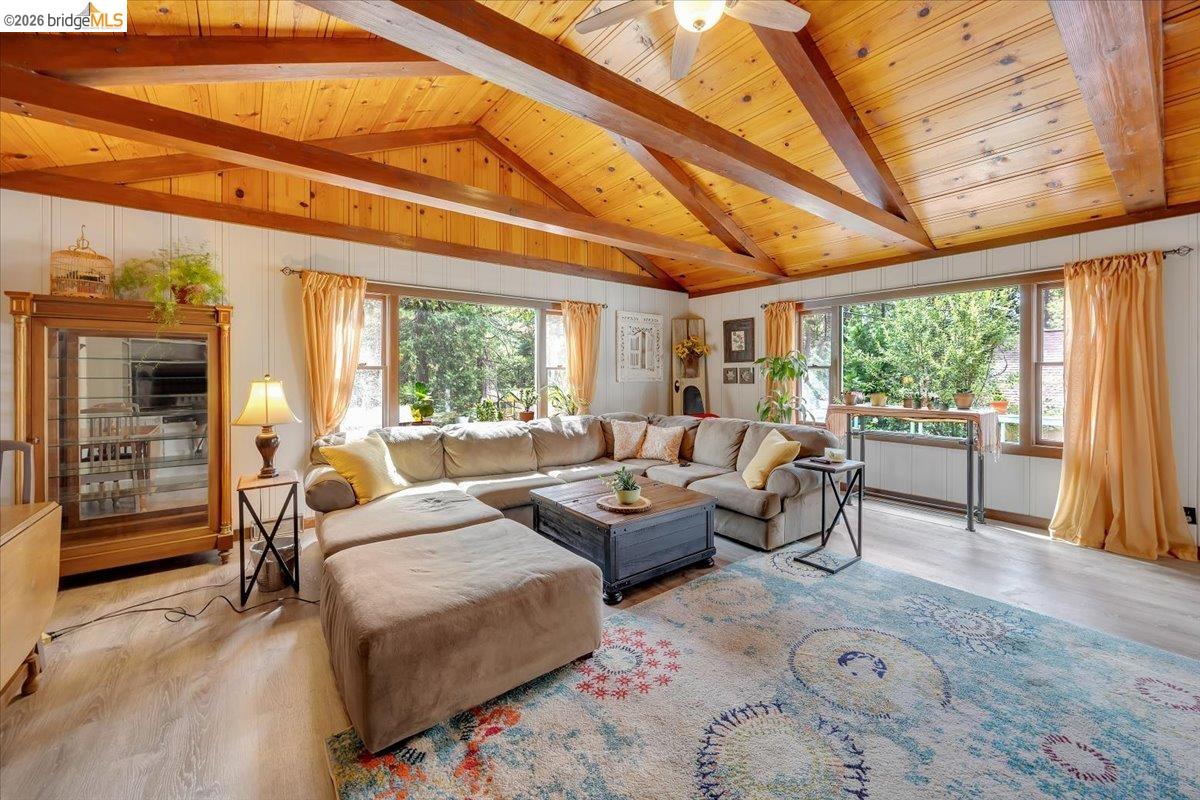 26144 Long Barn Road Long Barn, CA 95335 - Photo 7 of 42 Vaulted wood-paneled ceiling with exposed beams, wood-finish flooring, and multiple windows