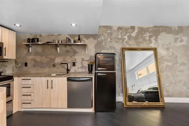 a kitchen with stainless steel appliances granite countertop a refrigerator and a stove