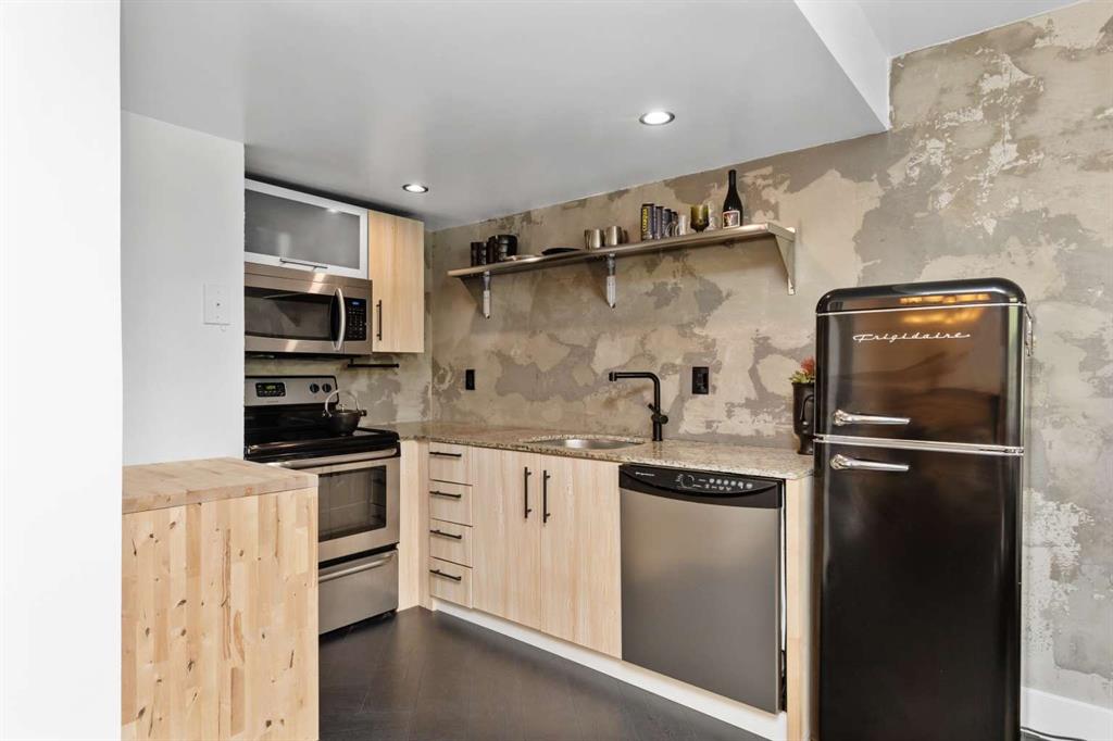 651 Northeast 60th Street, Unit 22 Miami, FL 33137 - Photo 2 of 12 a kitchen with stainless steel appliances a refrigerator sink and microwave