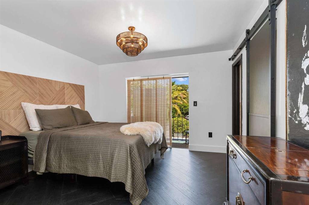 651 Northeast 60th Street, Unit 22 Miami, FL 33137 - Photo 5 of 12 a bedroom with a bed and a chandelier