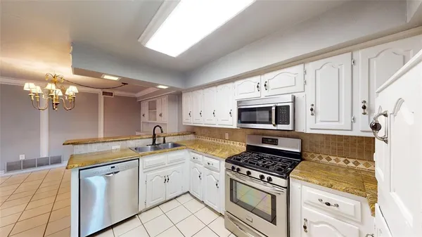 a kitchen with stainless steel appliances granite countertop a sink a refrigerator and a stove