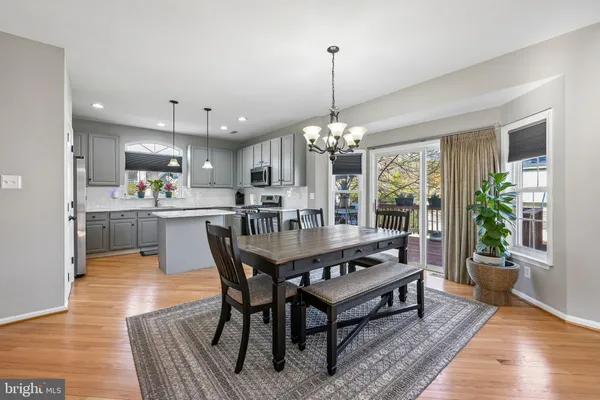 a dining room with furniture a chandelier and wooden floor