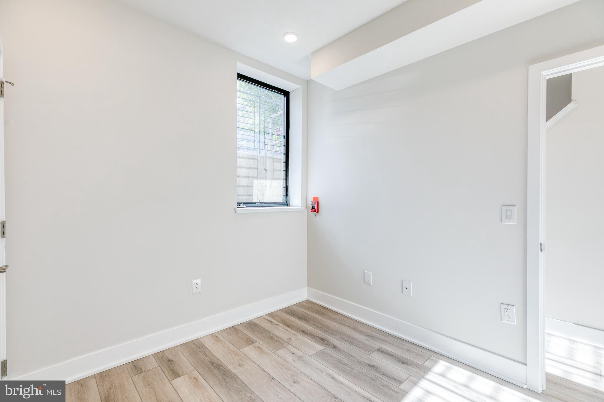 1506 North 8th Street, Unit 1 Philadelphia, PA 19122 - Photo 12 of 18 an empty room with wooden floor and windows