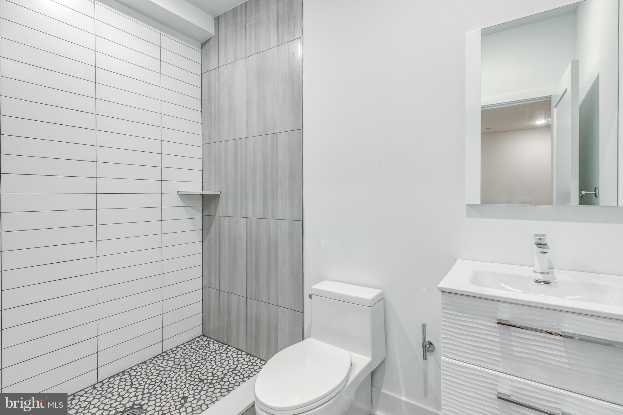 1506 North 8th Street, Unit 1 Philadelphia, PA 19122 - Photo 13 of 18 a bathroom with a sink a toilet and shower