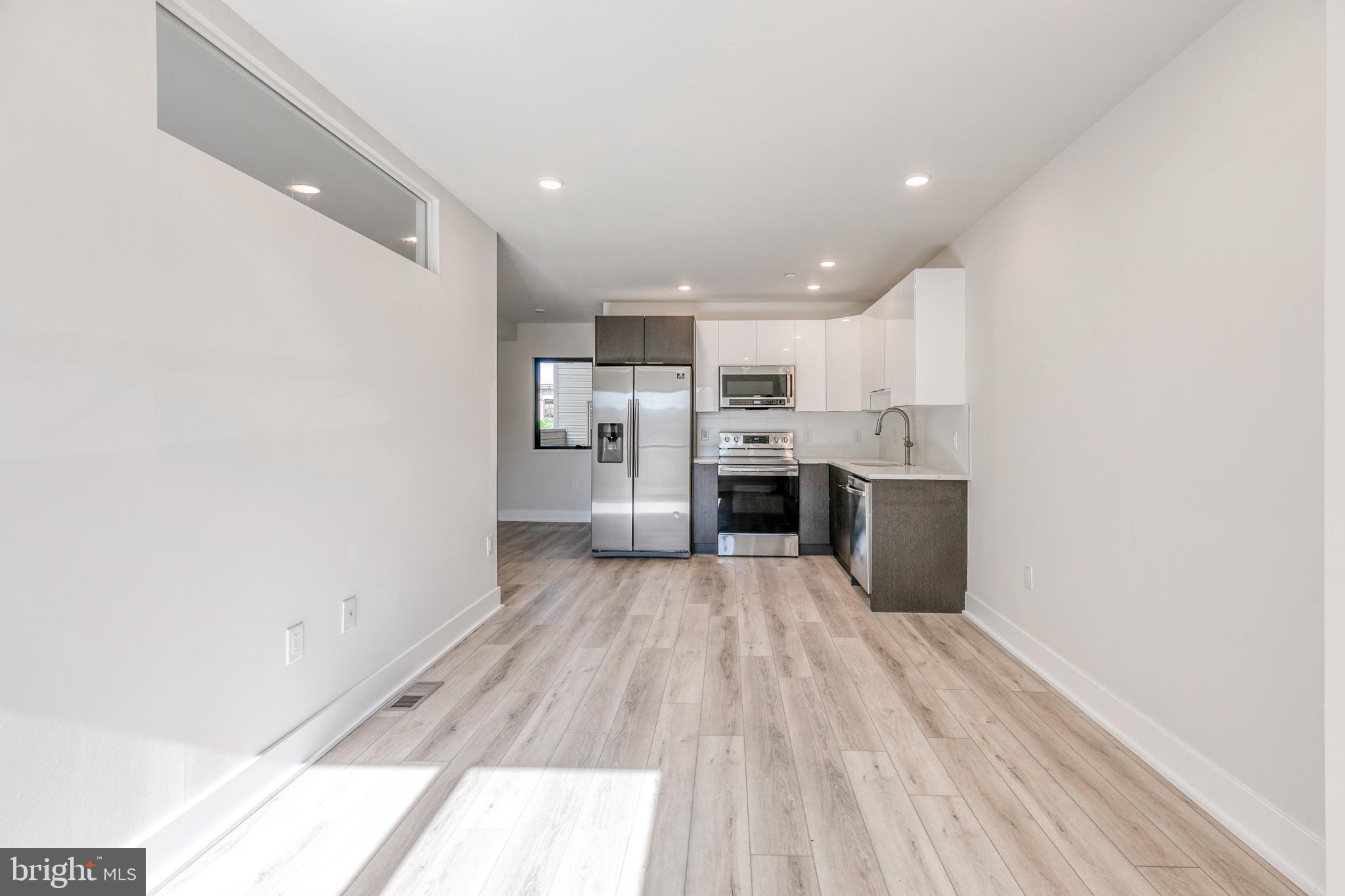 1506 North 8th Street, Unit 1 Philadelphia, PA 19122 - Photo 4 of 18 a view of kitchen with stainless steel appliances refrigerator stove microwave and cabinets