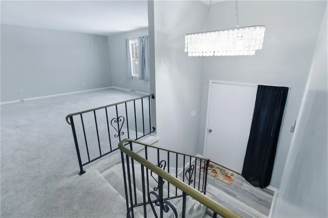 a view of staircase with railing and white walls