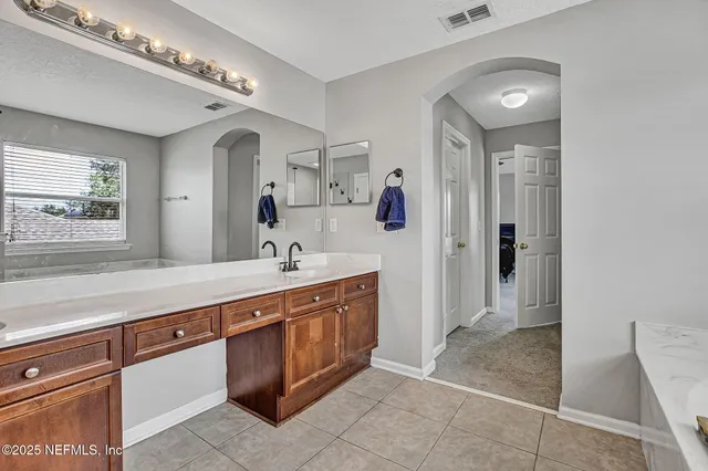 a spacious bathroom with a sink a mirror and a shower