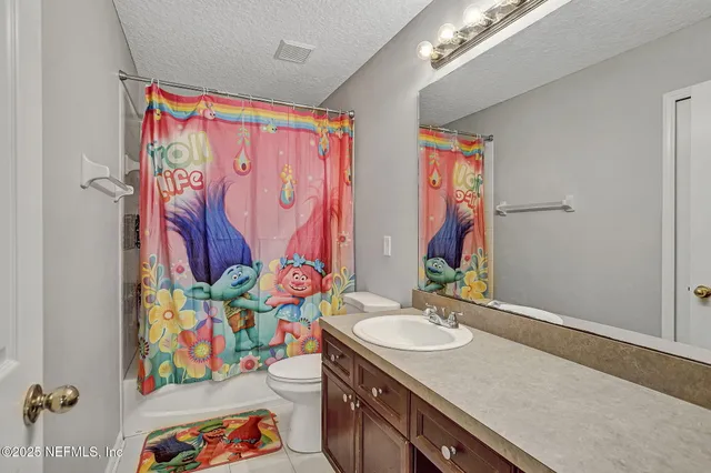 a bathroom with a sink a vanity and a curtain