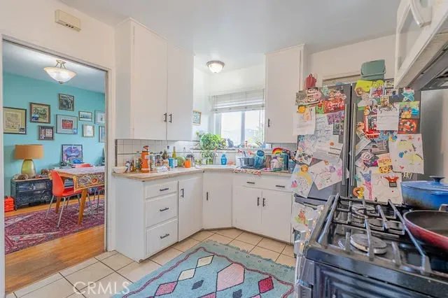 a storage room with lots of clutter and white cabinets