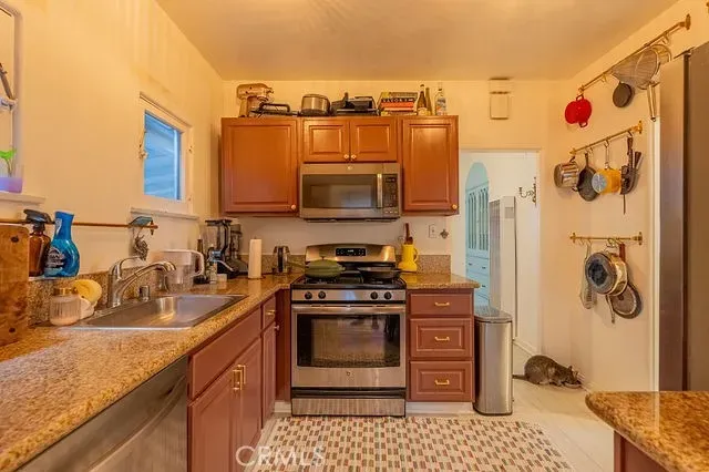 a kitchen with stainless steel appliances granite countertop a sink stove and cabinets