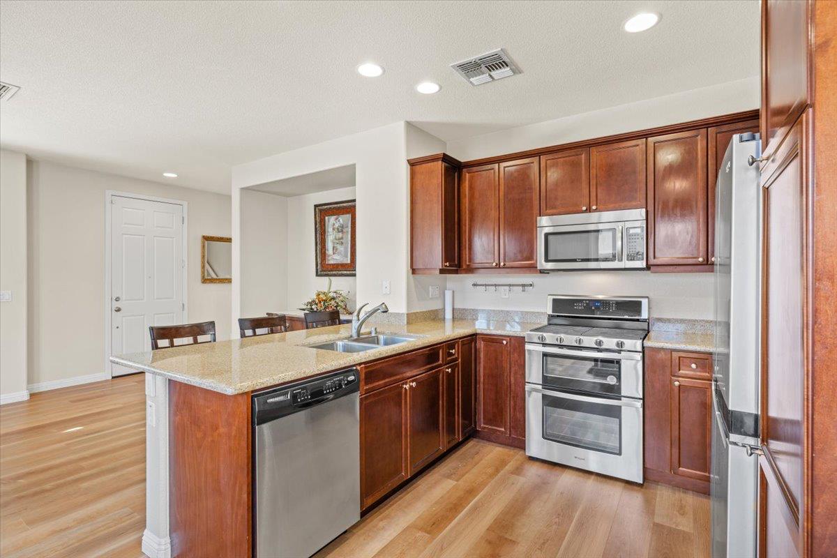 1000 Impressionist Loop Roseville, CA 95747 - Photo 8 of 33 a kitchen with stainless steel appliances a sink stove and cabinets
