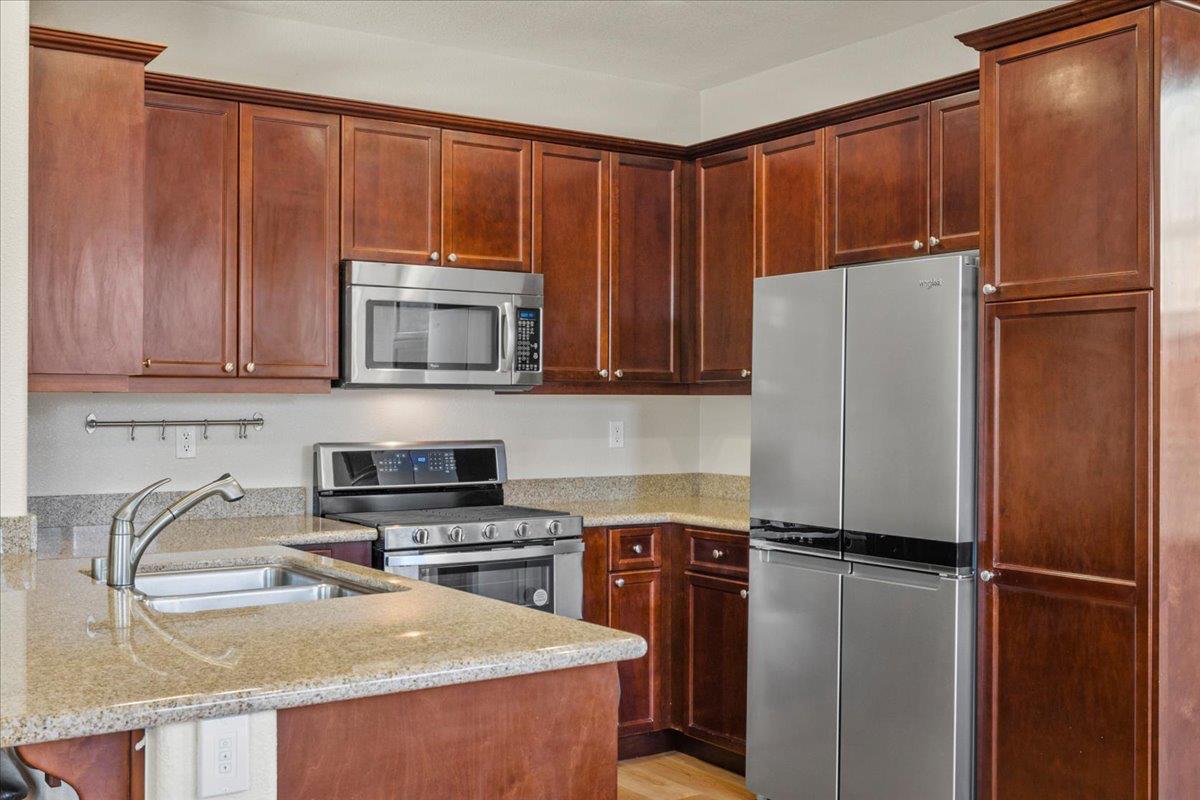 1000 Impressionist Loop Roseville, CA 95747 - Photo 9 of 33 a kitchen with a refrigerator a microwave and cabinets
