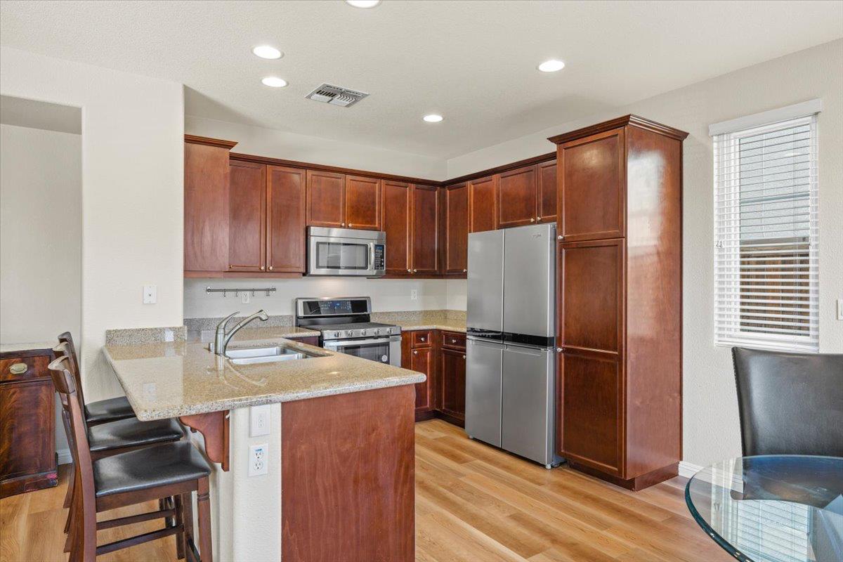 1000 Impressionist Loop Roseville, CA 95747 - Photo 10 of 33 a kitchen with wooden cabinets and stainless steel appliances