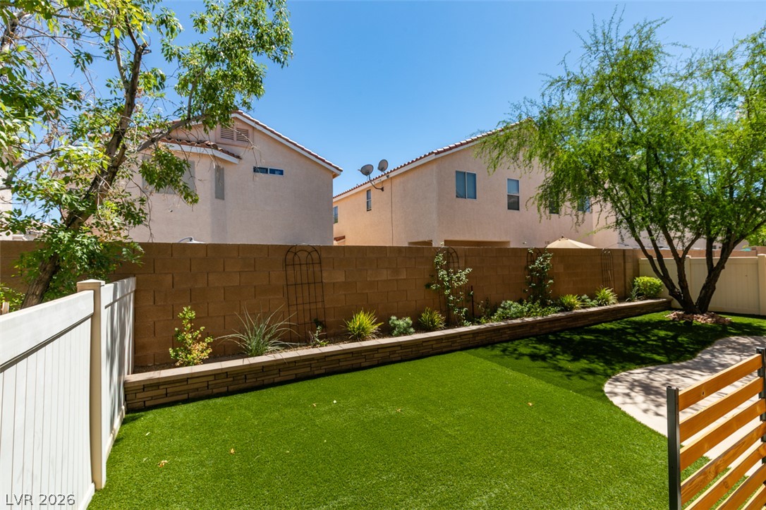8909 Houston Ridge Avenue Las Vegas, NV 89178 - Photo 42 of 45 Green landscaping and a privacy wall create an appealing outdoor retreat.