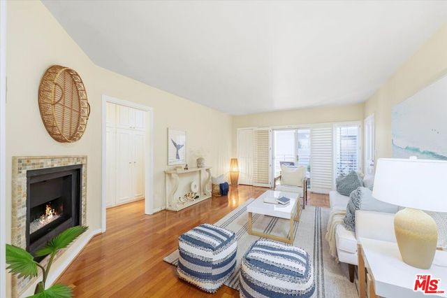a living room with furniture a fireplace and a large window