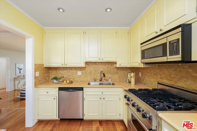 a kitchen with stainless steel appliances granite countertop a stove a sink and a microwave