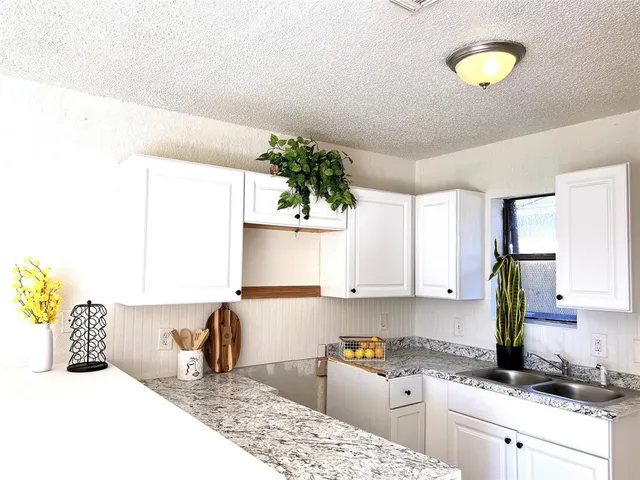 a kitchen with a sink cabinets and window