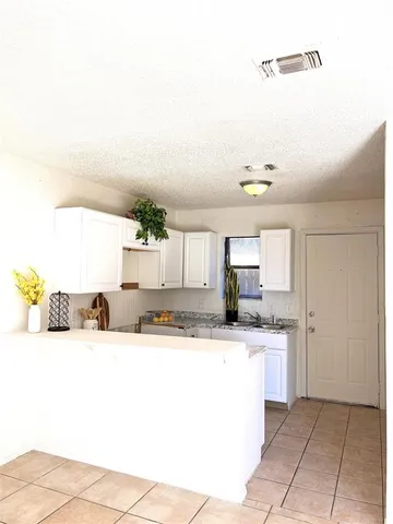 a kitchen with kitchen island granite countertop a sink and cabinets