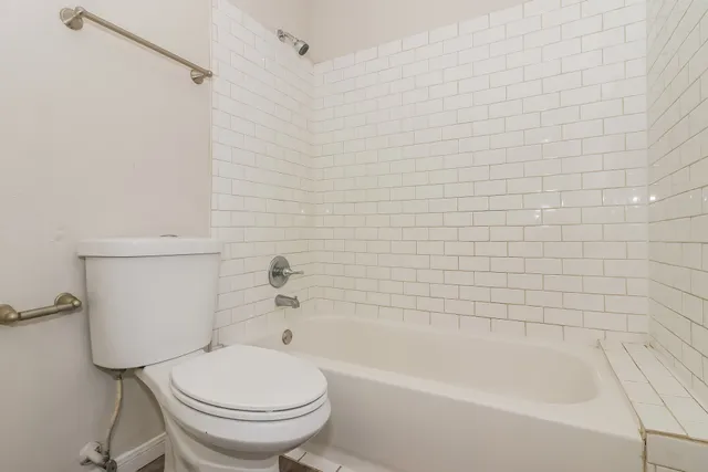 a white bath tub sitting next to a toilet