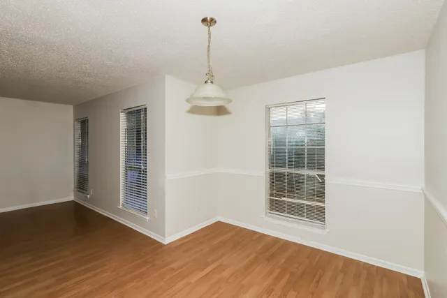 a view of a room with wooden floor and windows