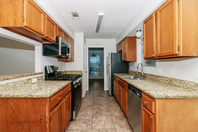 a kitchen with granite countertop a sink and a stove