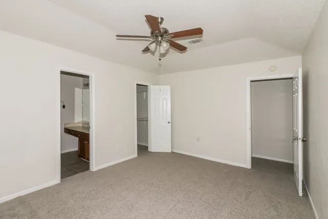 a view of an empty room with a ceiling fan
